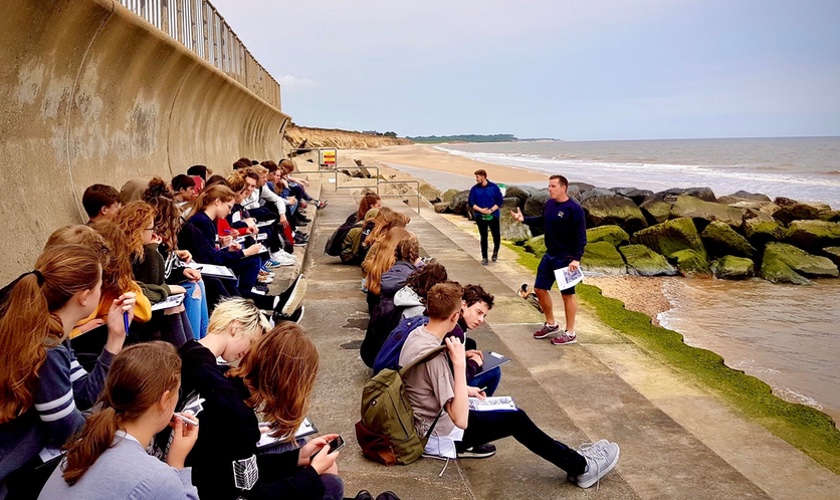 Students sitting next to a sea wall